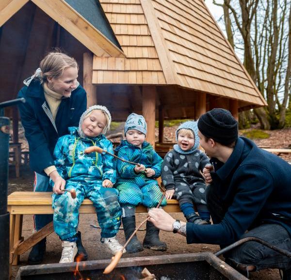 Familie rister pølser ved Max Henius hytten i Rebild Bakker